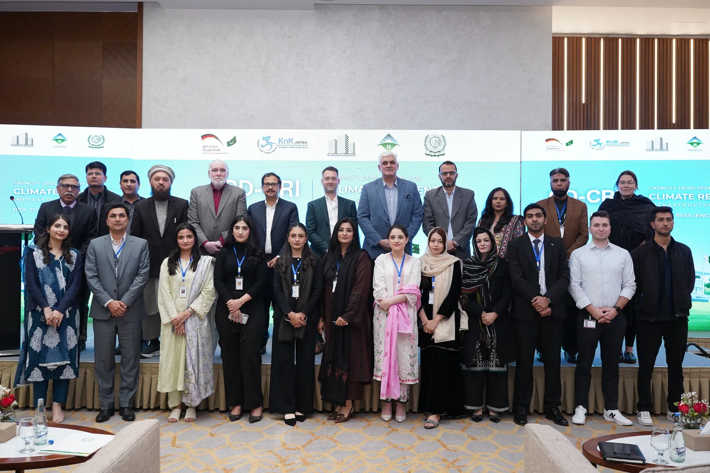 Partners from KnK Japan, the Pakistan Engineering Council and the NDRMF at the CD-CRI consultation in Islamabad, with partner banners behind them.