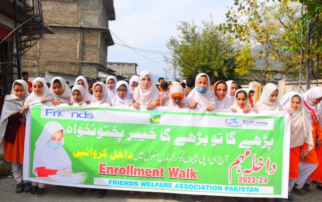Students and community members on an enrolment walk with a banner.