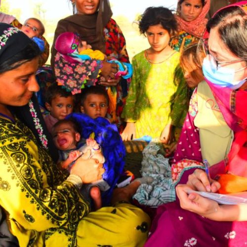 A health worker registering mothers and children