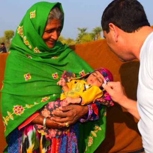 A health worker weighing an infant during a screening