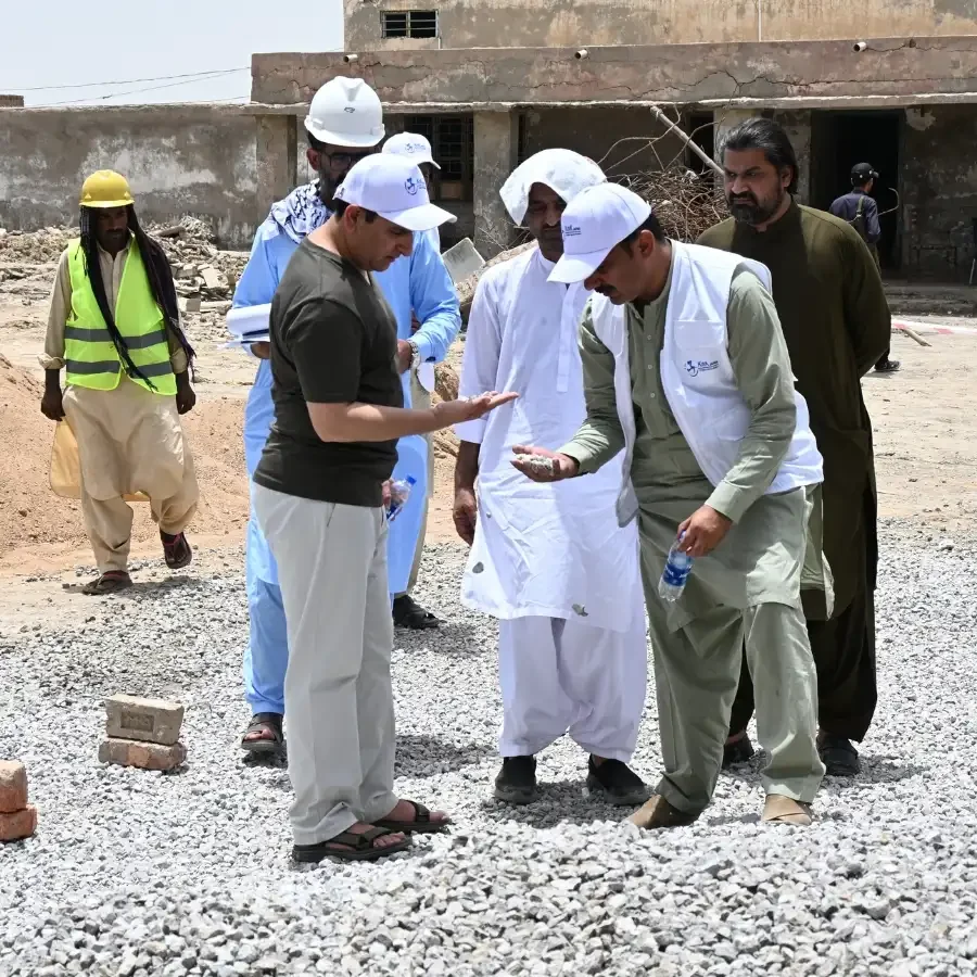 KnK Japan staff examining aggregate by hand at a construction site.