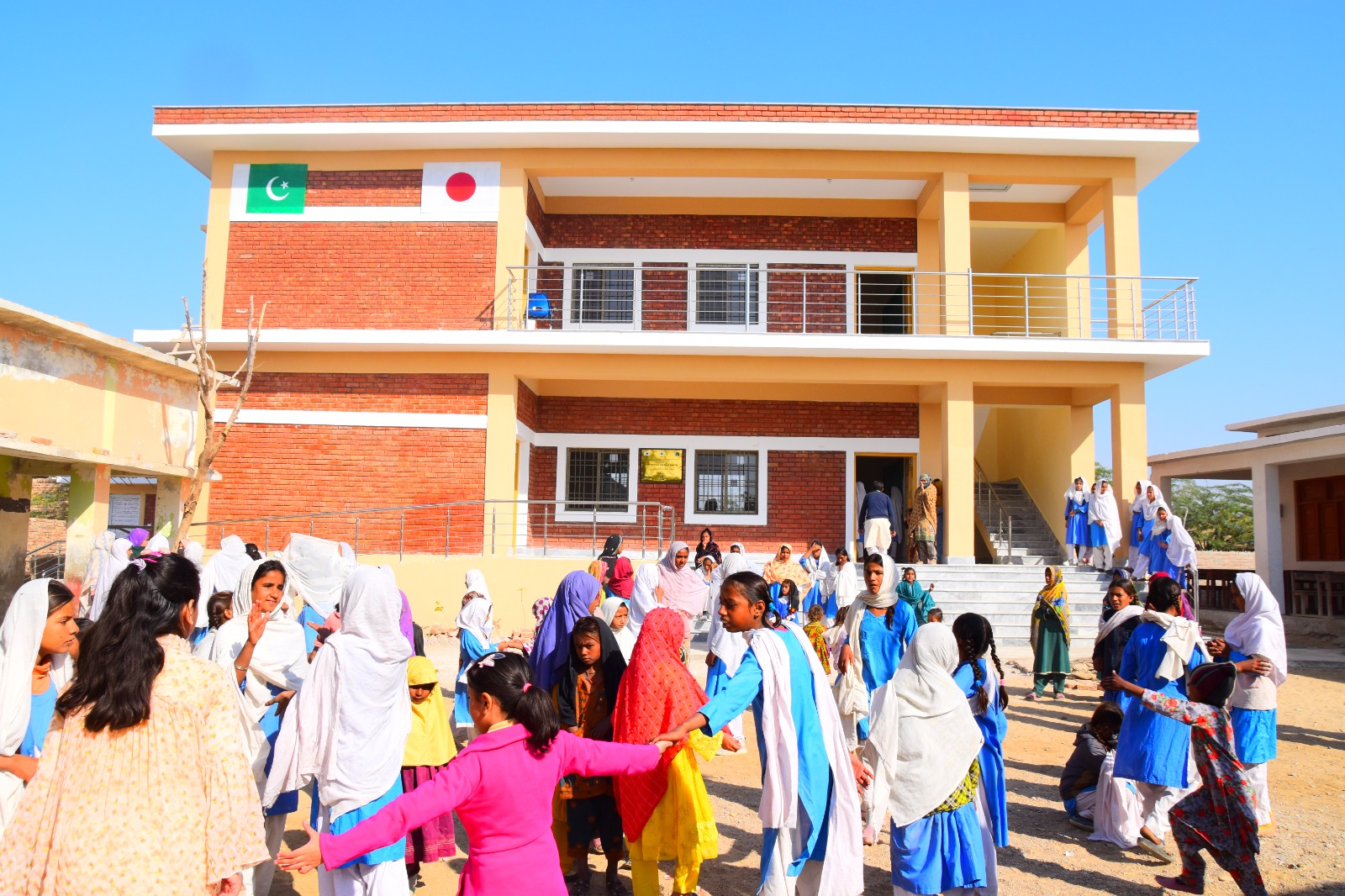 Students gathered in the courtyard in front of a newly opened KnK Japan two-storey school